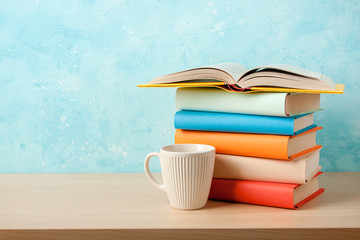 Stack of books and mug on wooden table
