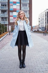 Portrait of stylish pretty young woman in autumn fashion walking in the city