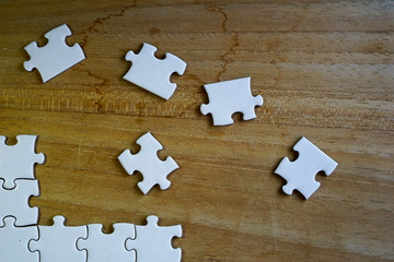 Close up incomplete jigsaw puzzle pieces on wooden table background