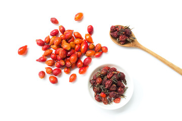 Set of fresh and dried wild rose berries on a white background. Rosehip in a wooden spoon. View from above.