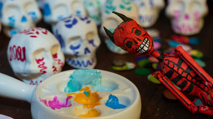Fototapeta na wymiar Pintando calaveritas de azúcar para día de muertos manualidad artesanía mexicana tradicional decoración diablito