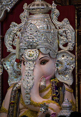 Obraz premium Close up portrait view of decorated and garlanded idol of Hindu God Ganesha.