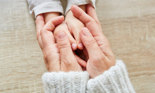 Senioren H&auml;nde halten H&auml;nde von Kind als Trost