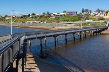 Fototapeta na wymiar The footbridge crossing over the Onkaparinga River mouth at Port Noarlunga South Australia on August 25th 2020