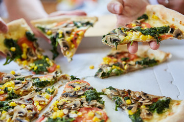 Freunde essen vegetarische Gemüse Pizza zusammen