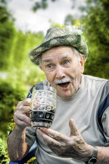 Portrait of a handsome elderly man of 87 years old, drinking a cool drink in the garden after work....