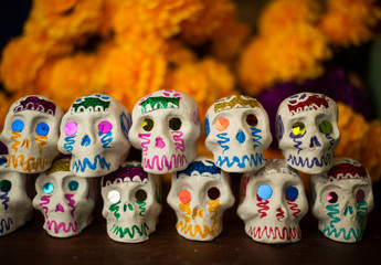 Fototapeta na wymiar Calaveritas de día de muertos hechas a mano artesanía mexicana cempasúchil tagetes erecta damasquina