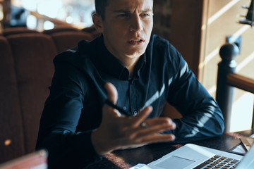 Business man freelancer with laptop in cafe at the table manager documents cup of coffee model