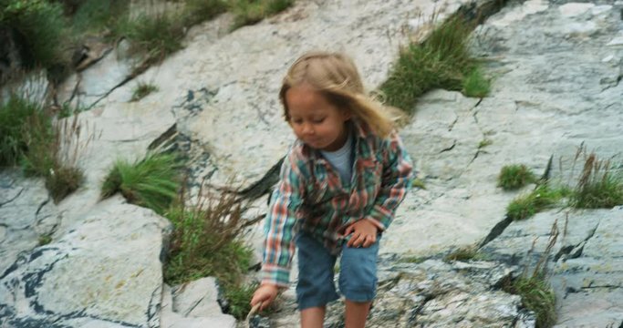 Preschooler climbing on rocks in nature