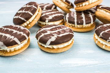 cookies with white filling and chocolate glaze on the table