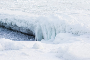 Natural sea ice blocks breaking up against the shore and ice during freezing winter weather. In the background