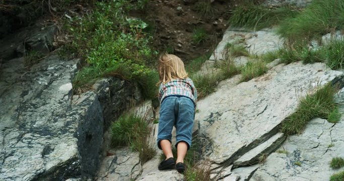 Preschooler climbing on rocks in nature