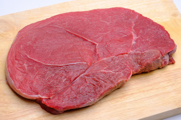 raw fresh beef knuckle steak cut on wood cutting board  isolated on white background