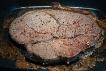 preparing a beef steak on a hot pan