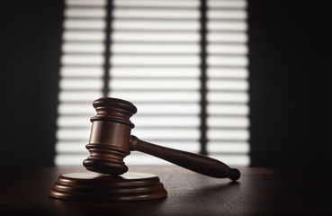 Judge (auction) gavel in the office against the background of a window with shutters