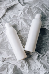 bottles of cosmetics on white crumpled paper