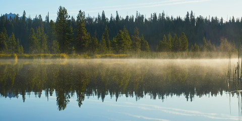 Misty morning panorama on the Hosmer Lake in central Oregon.