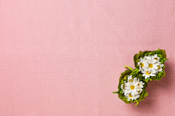 White flowers on Pink tablecloth fabric texture background. Top view