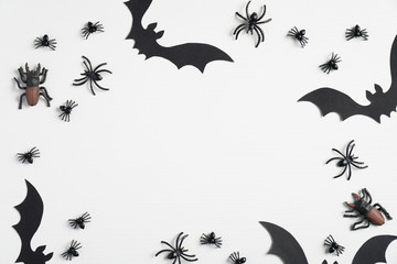 Halloween composition. Frame of halloween decorations, bats and spiders on white background. Flat lay, top view. Happy halloween concept.