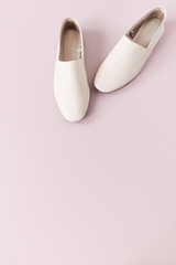 Fashion collage with women's white leather slippers on pink. Minimal flat lay, top view lifestyle concept.