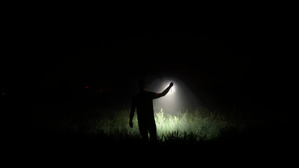 Person with flashlight at night - obrazy, fototapety, plakaty