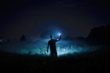 Person with flashlight at night - Powered by Adobe