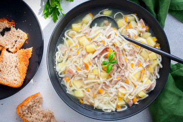 Homemade noodle soup with duck in black plate, selective focus