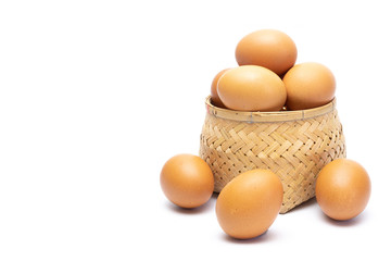 Fresh chicken eggs in the bamboo woven and on the floor isolated on white background. selective focus, soft focus.