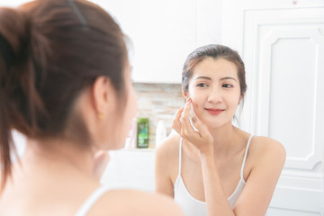 Obraz na płótnie Canvas Asian Beauty Woman apply face cream in bathroom.
