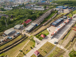 Multicolored freight containers on the railroad. Aerial drone view.