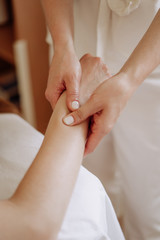 Obraz na płótnie Canvas Masseuse Massaging Client Wrist Spa Salon Cabinet