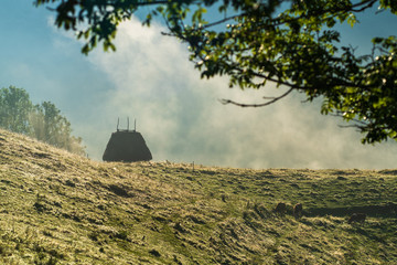 Picturesque landscape from a Romanian hamlet with a lonely rustic house on a high hill and the...