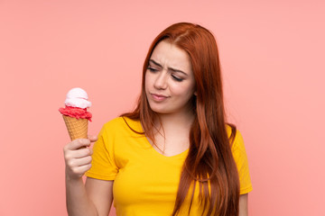 Young girl with a cornet ice cream over isolated background with sad expression
