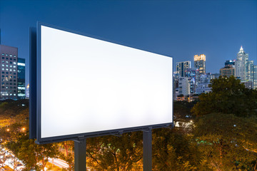 Blank white road billboard with Bangkok cityscape background at night time. Street advertising poster, mock up, 3D rendering. Side view. The concept of marketing communication to sell idea.