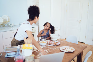 Happy ethnic kid cooking with parent