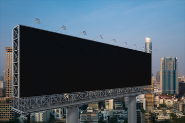 Blank black road billboard with Bangkok cityscape background at sunset. Street advertising poster, mock up, 3D rendering. Side view. The concept of marketing communication to promote or sell idea.