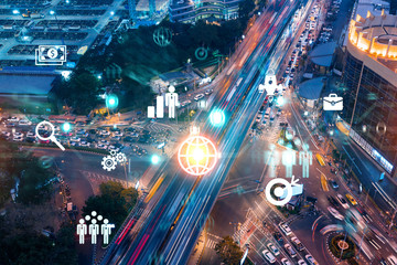 Research and development hologram on aerial view of road, busy urban traffic highway at night. Junction network of transportation infrastructure. Concept of innovative logistics. Double exposure.