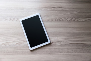 White tablet pc with empty screen on wood background