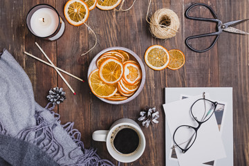 Dry oranges, coffee and candle on wooden table.