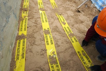 Underground warning tape placed on the sand to alert the underground power lines in the chemical...