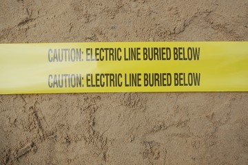 Underground warning tape placed on the sand to alert the underground power lines in the chemical...