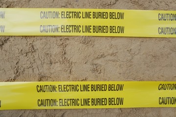 Underground warning tape placed on the sand to alert the underground power lines in the chemical...