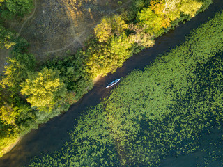 Kayak boat in the green water of the Dnieper river. Aerial drone view.