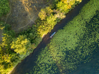 Kayak boat in the green water of the Dnieper river. Aerial drone view.