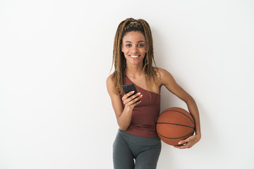 Cheery african sports woman with basketball