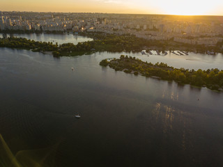 Aerial drone view. Bank of the Dnieper River in Kiev in the evening in the rays of the setting sun.