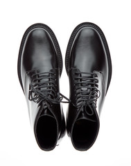 Classic black plain toe boots made of durable glossy leather with a small lace-up heel, isolated on a white background with a shadow. Top view.