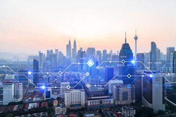 Glowing hologram of technological process, aerial panoramic cityscape of Kuala Lumpur at sunset. KL is the largest innovative hub of tech services in Malaysia, Asia. Multi exposure.