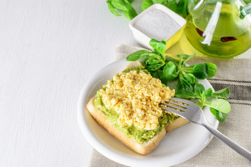 Toast of avocado and egg, lettuce on the plate. Ketogenic healthy diet breakfast.