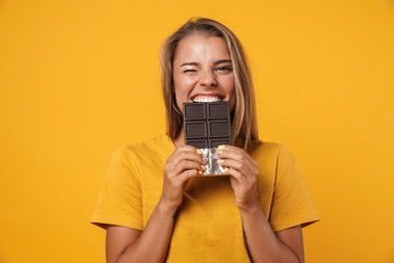 Image of blonde joyful woman winking and holding chocolate